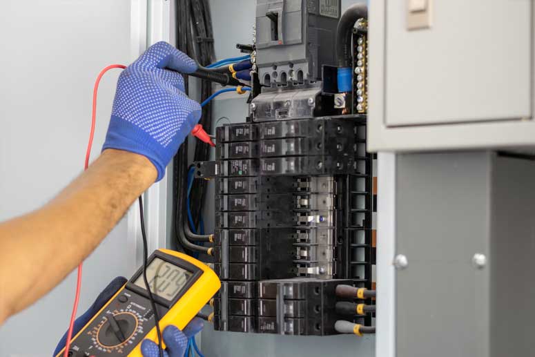 Electrician testing electrical panel circuits